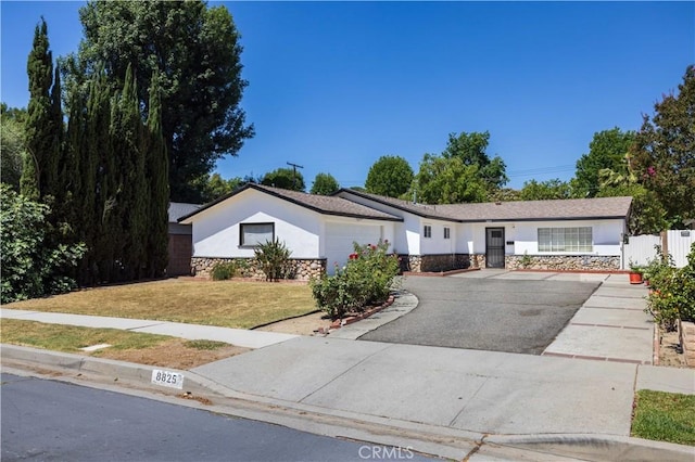 8825 Sophia Ave, North Hills, CA 91343 - ranch-style house featuring stone siding, stucco siding, an attached garage, and driveway