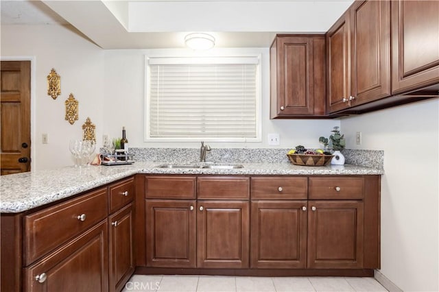 8825 Sophia Ave, North Hills, CA 91343 - kitchen with light stone counters, a peninsula, and light tile patterned flooring