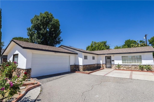8825 Sophia Ave, North Hills, CA 91343 - ranch-style house featuring stone siding, stucco siding, asphalt driveway, and an attached garage