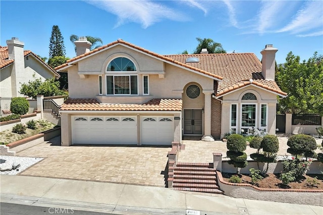 20455 Via Canarias, Yorba Linda, CA 92887 - mediterranean / spanish-style home featuring an attached garage, decorative driveway, stucco siding, and a tile roof