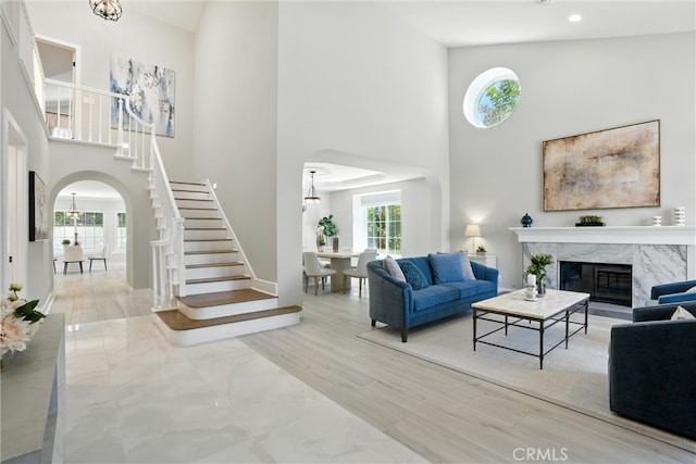 20455 Via Canarias, Yorba Linda, CA 92887 - living room featuring arched walkways, a high ceiling, stairway, plenty of natural light, and a premium fireplace