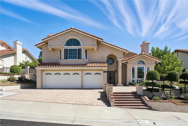 20455 Via Canarias, Yorba Linda, CA 92887 - mediterranean / spanish-style home with driveway, an attached garage, stucco siding, a tile roof, and a chimney