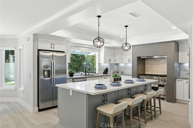 20455 Via Canarias, Yorba Linda, CA 92887 - kitchen featuring appliances with stainless steel finishes, backsplash, crown molding, a kitchen island, and light wood-style flooring
