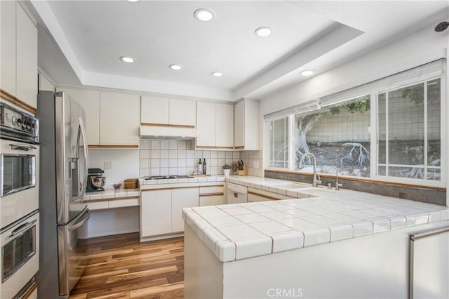 25632 Adriana St, Mission Viejo, CA 92691 - kitchen featuring stainless steel appliances, light wood-type flooring, tile counters, recessed lighting, and tasteful backsplash