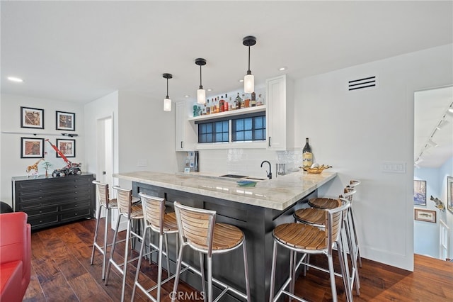 2115 Kathryn Way, Placentia, CA 92870 - kitchen featuring a kitchen bar, backsplash, dark wood-style flooring, white cabinets, and recessed lighting