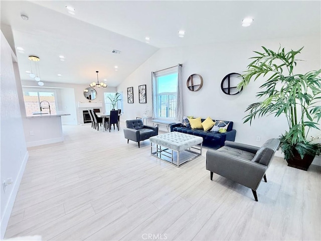 1421 Wildflower St, Rialto, CA 92377 - living area with lofted ceiling, plenty of natural light, a chandelier, and light wood-style flooring