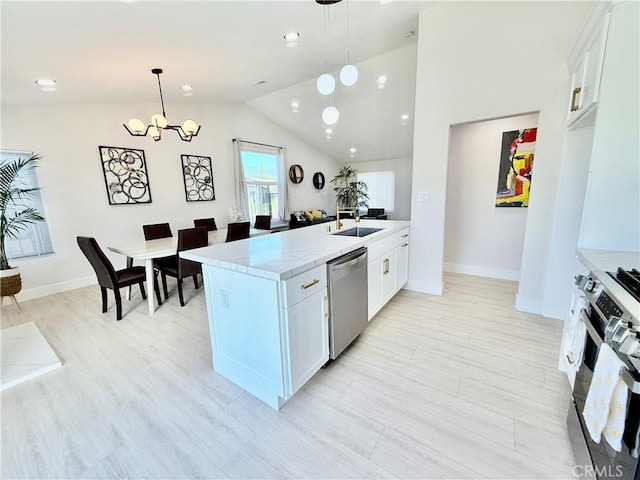 1421 Wildflower St, Rialto, CA 92377 - kitchen with stainless steel appliances, lofted ceiling, white cabinetry, a chandelier, and light stone counters