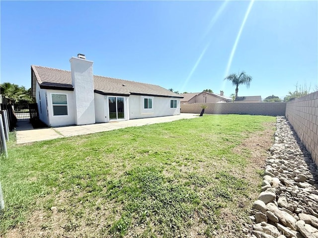 1421 Wildflower St, Rialto, CA 92377 - rear view of house featuring a patio, a fenced backyard, a chimney, a tiled roof, and stucco siding