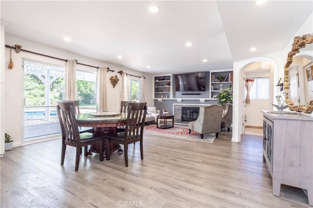 11721 Killimore Ave, Porter Ranch, CA 91326 - dining area featuring plenty of natural light, recessed lighting, a high end fireplace, light wood finished floors, and arched walkways