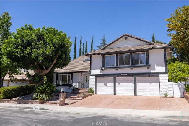 11721 Killimore Ave, Porter Ranch, CA 91326 - view of front facade with stucco siding, an attached garage, concrete driveway, and a tile roof