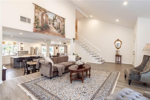 11721 Killimore Ave, Porter Ranch, CA 91326 - living room with high vaulted ceiling, plenty of natural light, light wood-style flooring, stairway, and recessed lighting