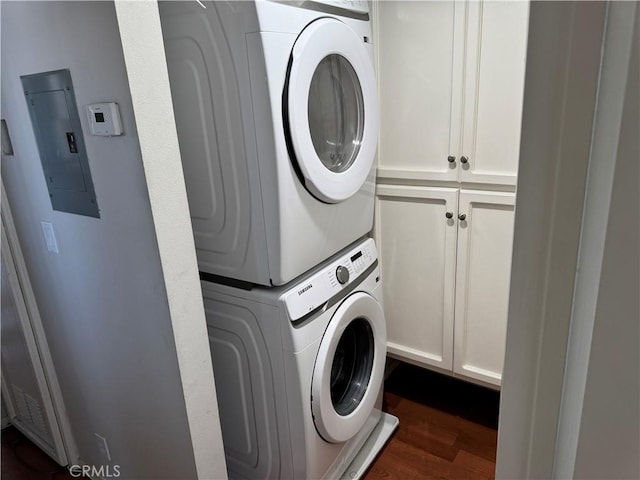 1549 W 146th St Unit 9, Gardena, CA 90247 - laundry area featuring stacked washer / dryer, electric panel, dark wood-style flooring, and cabinet space