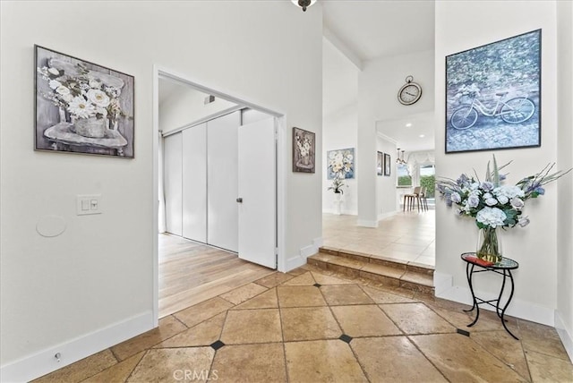 21211 Poston Ln, Huntington Beach, CA 92646 - hall featuring inlaid floor details, a towering ceiling, and tile patterned flooring
