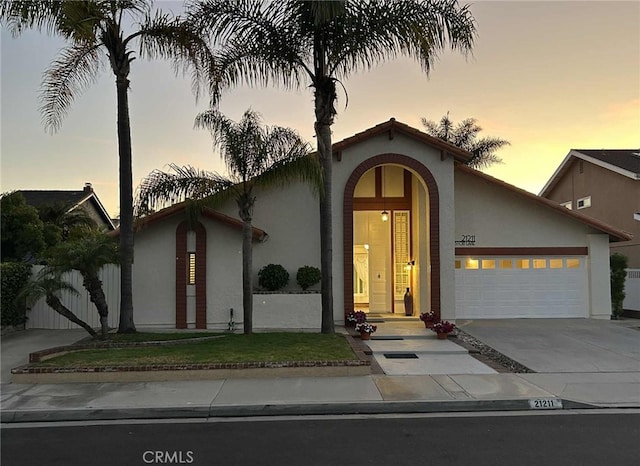 21211 Poston Ln, Huntington Beach, CA 92646 - mediterranean / spanish home with stucco siding, a garage, and concrete driveway