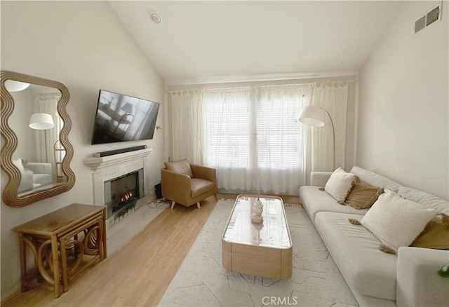 8655 Moody St, Cypress, CA 90630 - living area with wood finished floors, vaulted ceiling, and a lit fireplace