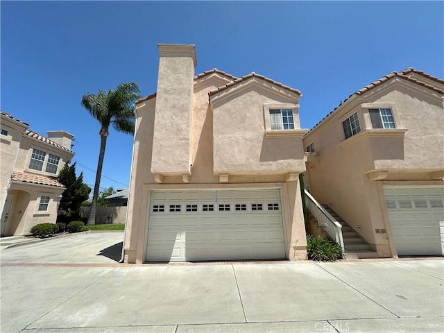 8655 Moody St, Cypress, CA 90630 - view of front of home with stucco siding, a chimney, a garage, and a tiled roof