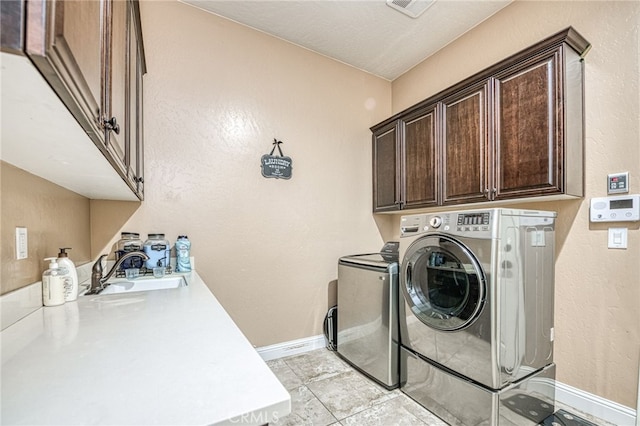 6626 W Alluvial Ave, Fresno, CA 93722 - laundry area with cabinet space, washing machine and dryer, and a textured wall