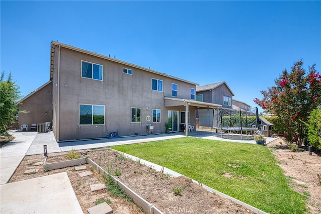 6626 W Alluvial Ave, Fresno, CA 93722 - back of property featuring a trampoline, a patio, a lawn, stucco siding, and a vegetable garden