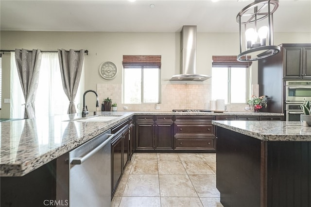 6626 W Alluvial Ave, Fresno, CA 93722 - kitchen with stainless steel appliances, wall chimney exhaust hood, tasteful backsplash, light stone counters, and hanging light fixtures
