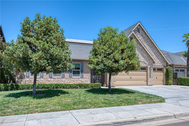 6626 W Alluvial Ave, Fresno, CA 93722 - view of front of property featuring stone siding, solar panels, a garage, a front yard, and driveway