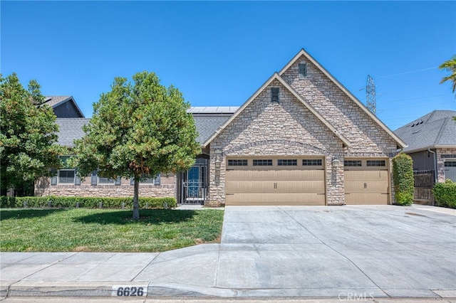 6626 W Alluvial Ave, Fresno, CA 93722 - view of front of property with stone siding, concrete driveway, a front yard, a garage, and solar panels