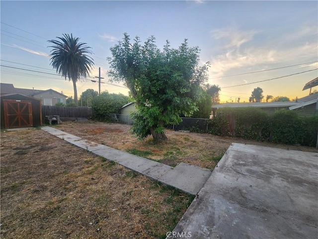 4317 Lugo Ave, Chino Hills, CA 91709 - yard at dusk with a fenced backyard, a patio, and a storage shed