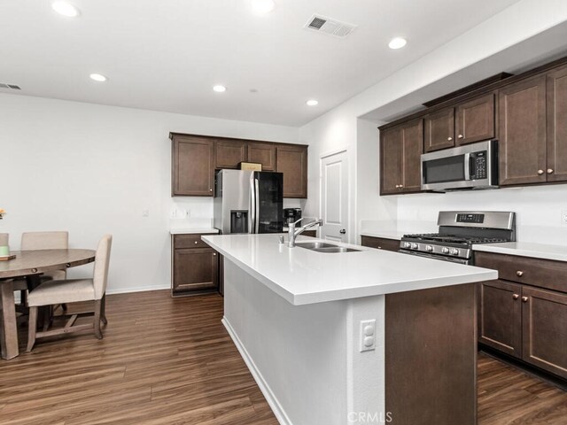 29425 Bovenzi Way, Winchester, CA 92596 - kitchen with appliances with stainless steel finishes, dark wood-style flooring, dark brown cabinets, light countertops, and recessed lighting