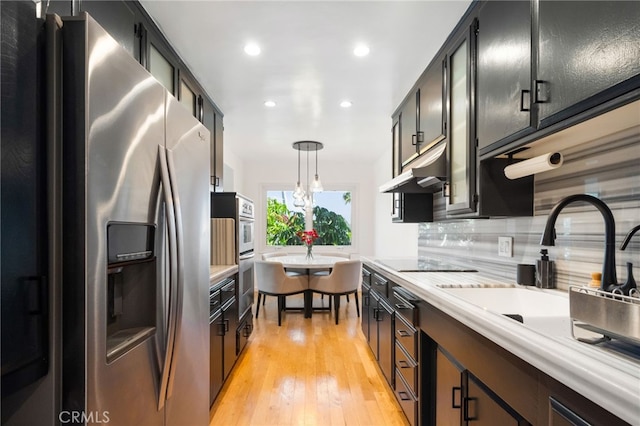 3407 Huxley St Unit 31, Los Angeles, CA 90027 - kitchen featuring appliances with stainless steel finishes, under cabinet range hood, dark cabinets, light countertops, and recessed lighting