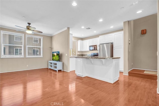 2019 Arnold Way, Fullerton, CA 92833 - kitchen featuring appliances with stainless steel finishes, a kitchen bar, light wood-style floors, a ceiling fan, and ornamental molding