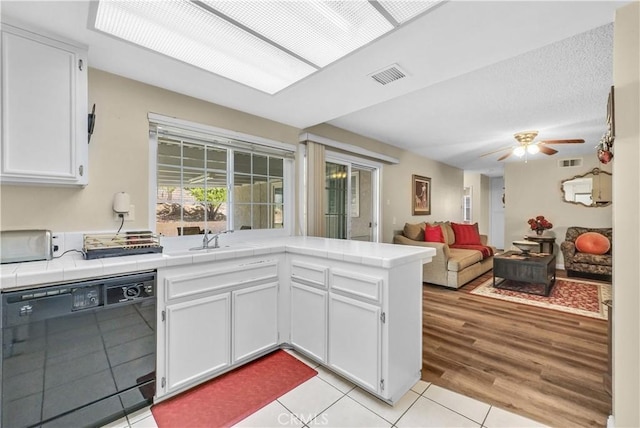 1135 Hampton Ct, San Dimas, CA 91773 - kitchen with black dishwasher, tile countertops, white cabinets, light tile patterned floors, and a peninsula