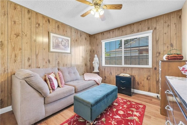 1135 Hampton Ct, San Dimas, CA 91773 - living area with wooden walls, a ceiling fan, a textured ceiling, and light wood-style floors