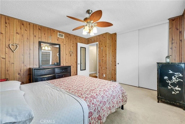 1135 Hampton Ct, San Dimas, CA 91773 - bedroom with light colored carpet, a closet, wood walls, a ceiling fan, and a textured ceiling