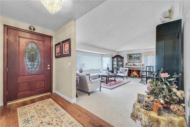 1135 Hampton Ct, San Dimas, CA 91773 - entrance foyer with wood finished floors, lofted ceiling, a textured ceiling, and a chandelier