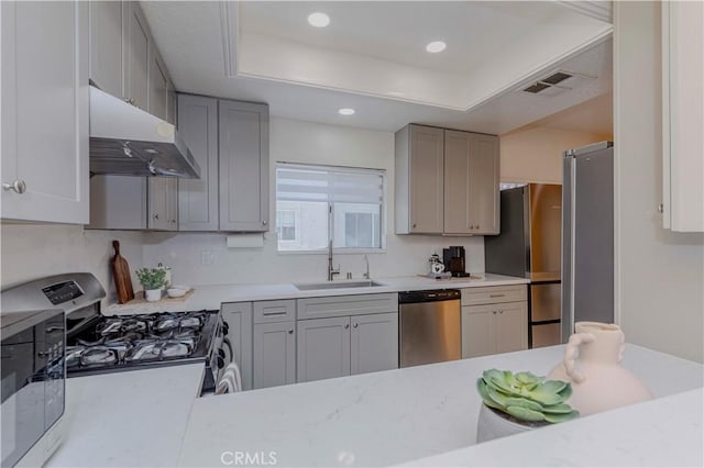 15034 Ocaso Ave, La Mirada, CA 90638 - kitchen featuring stainless steel appliances, under cabinet range hood, gray cabinetry, light countertops, and recessed lighting