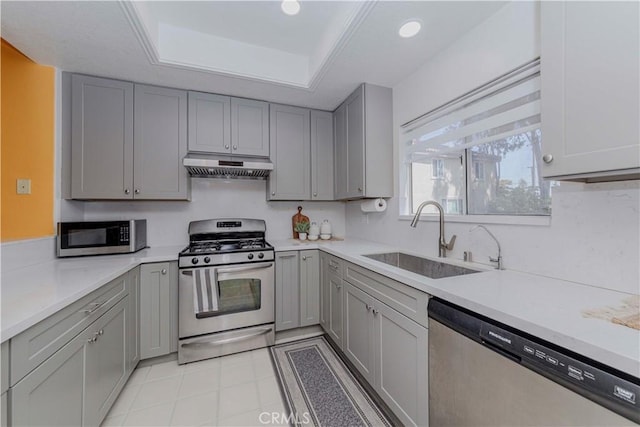 15034 Ocaso Ave, La Mirada, CA 90638 - kitchen featuring appliances with stainless steel finishes, under cabinet range hood, gray cabinets, light countertops, and recessed lighting