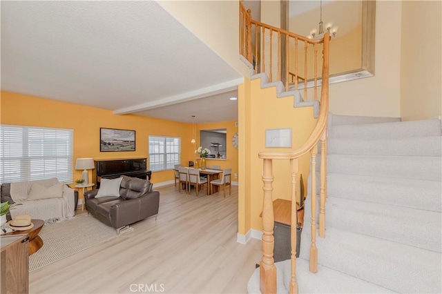 15034 Ocaso Ave, La Mirada, CA 90638 - living area featuring stairs, wood finished floors, beam ceiling, and a chandelier