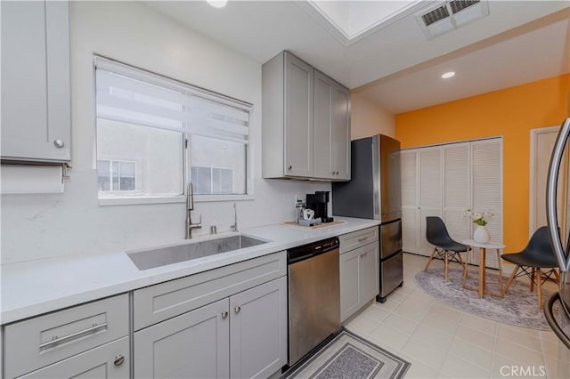 15034 Ocaso Ave, La Mirada, CA 90638 - kitchen with appliances with stainless steel finishes, gray cabinetry, light countertops, and light tile patterned floors