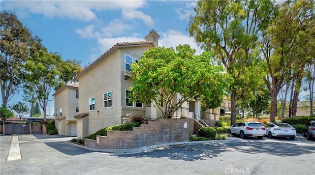 15034 Ocaso Ave, La Mirada, CA 90638 - view of front of house with stucco siding, a chimney, a tiled roof, and stairs