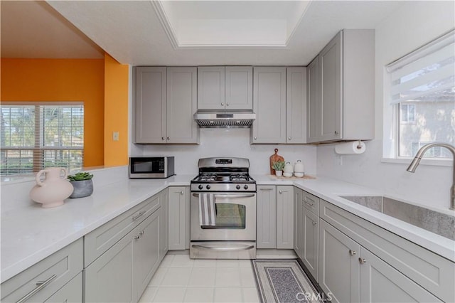 15034 Ocaso Ave, La Mirada, CA 90638 - kitchen featuring appliances with stainless steel finishes, under cabinet range hood, gray cabinets, and light countertops