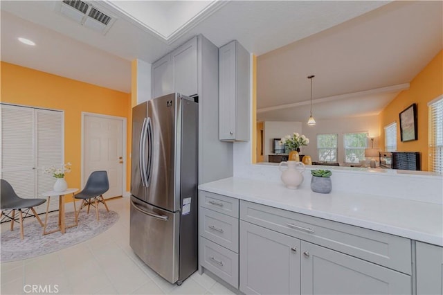 15034 Ocaso Ave, La Mirada, CA 90638 - kitchen with freestanding refrigerator, gray cabinetry, light countertops, light tile patterned floors, and decorative light fixtures