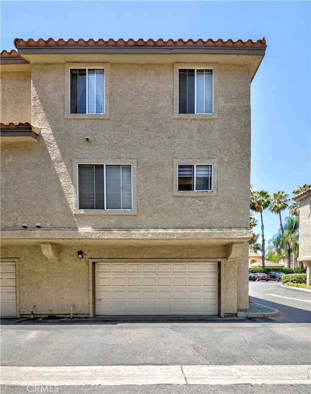 15034 Ocaso Ave, La Mirada, CA 90638 - back of property with stucco siding, an attached garage, and a tiled roof