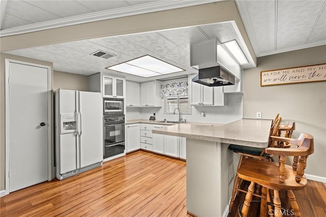 41050 Mohawk Cir, Cherry Valley, CA 92223 - kitchen featuring a peninsula, light wood-style floors, white fridge with ice dispenser, a breakfast bar, and white cabinets