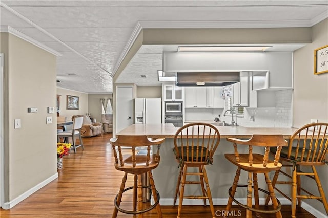 41050 Mohawk Cir, Cherry Valley, CA 92223 - kitchen featuring light wood-style flooring, a peninsula, white refrigerator with ice dispenser, backsplash, and light countertops