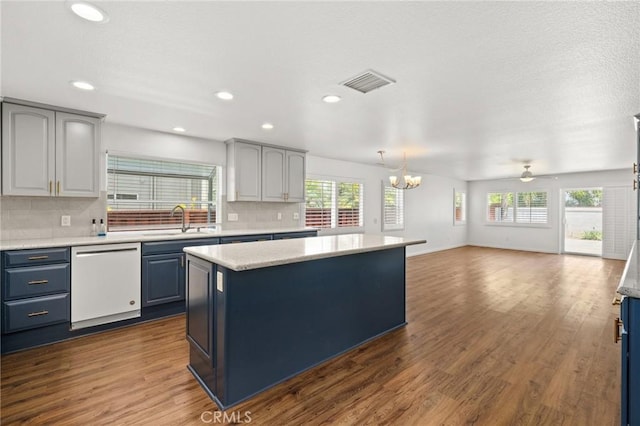 1167 Belridge Pl, Corona, CA 92881 - kitchen featuring dishwasher, blue cabinets, a kitchen island, a chandelier, and tasteful backsplash
