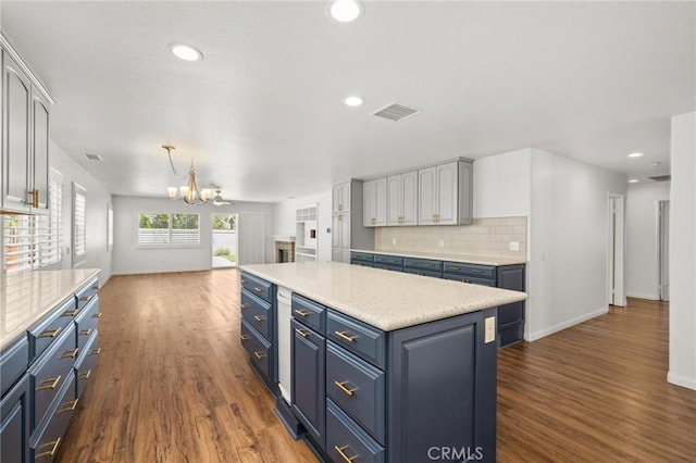 1167 Belridge Pl, Corona, CA 92881 - kitchen with blue cabinetry, a chandelier, dark wood finished floors, light countertops, and backsplash