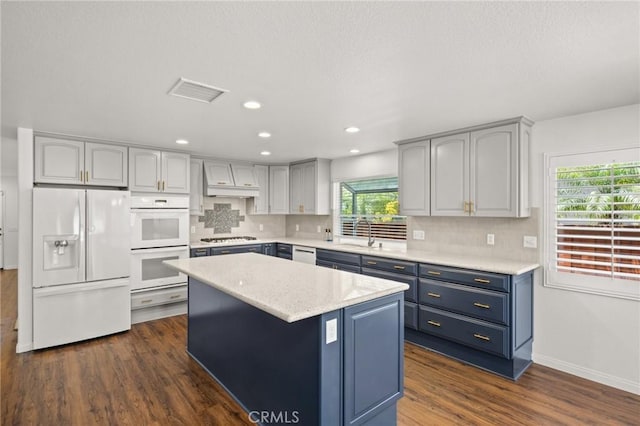 1167 Belridge Pl, Corona, CA 92881 - kitchen with white appliances, blue cabinetry, dark wood-style floors, a kitchen island, and backsplash