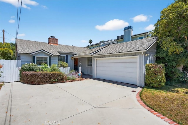 15747 Addison St, Encino, CA 91436 - view of front facade with board and batten siding, driveway, an attached garage, and a chimney