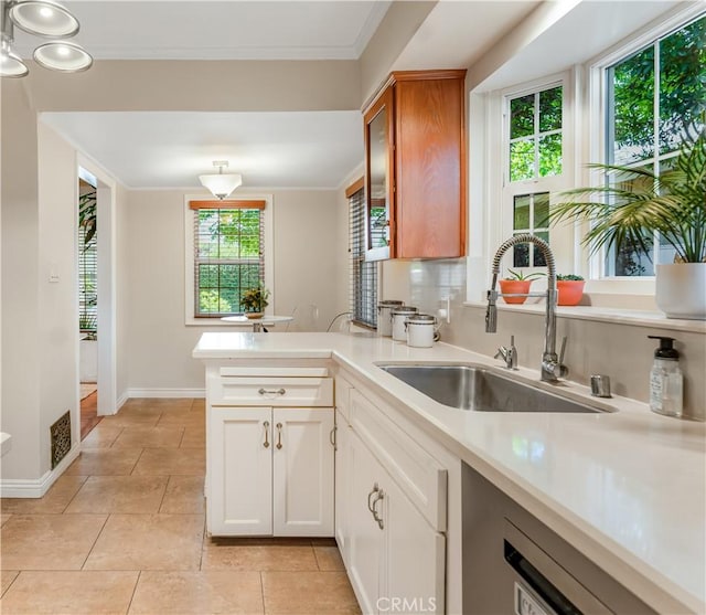 3935 Lime Ave, Long Beach, CA 90807 - kitchen with light countertops, a peninsula, light tile patterned flooring, crown molding, and glass insert cabinets