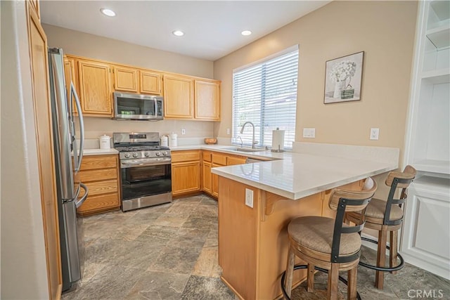 25868 Hammet Cir, Stevenson Ranch, CA 91381 - kitchen with appliances with stainless steel finishes, a peninsula, a breakfast bar, recessed lighting, and light countertops