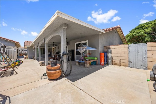 18043 Preston St, Hesperia, CA 92345 - rear view of property featuring a gate, ceiling fan, stucco siding, and a patio area
